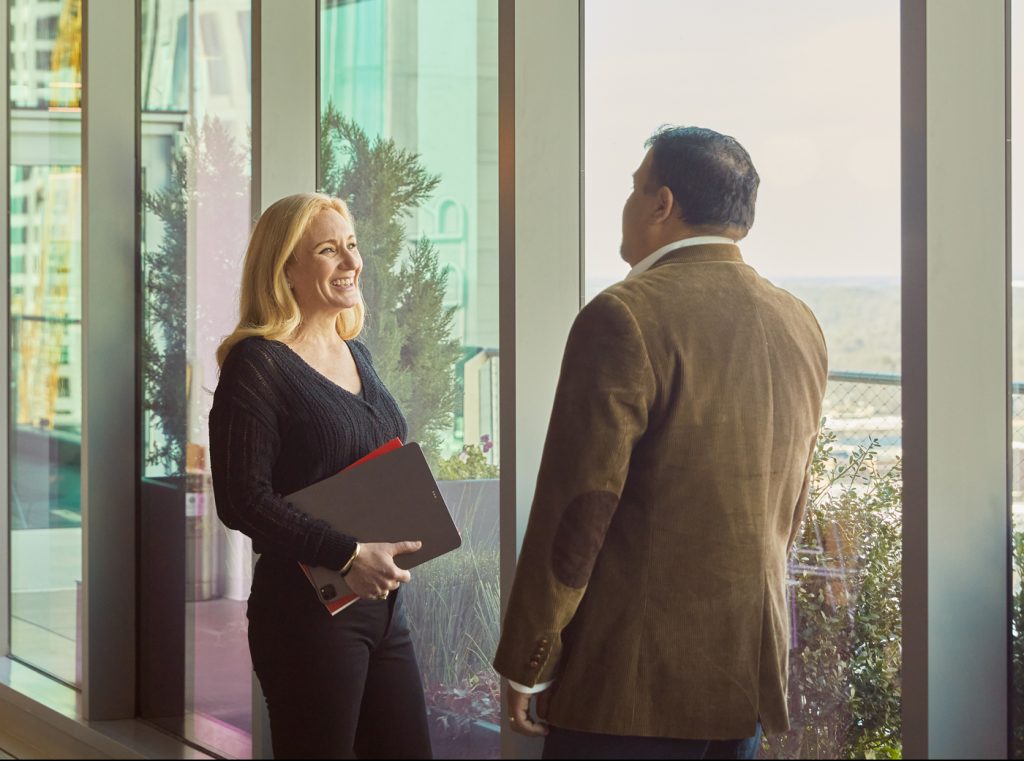 Photograph of people talking by window